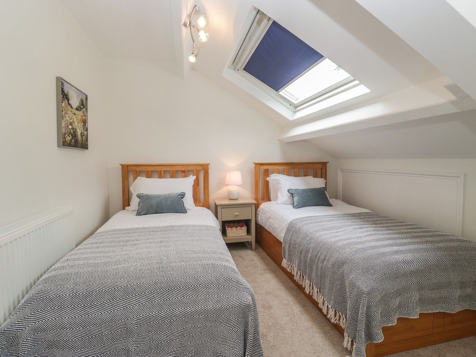 A bedroom with two single beds and a window at Cumbria house