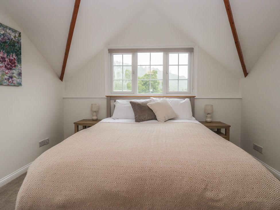 A bedroom with a bed and two bedside tables at Cumbria house