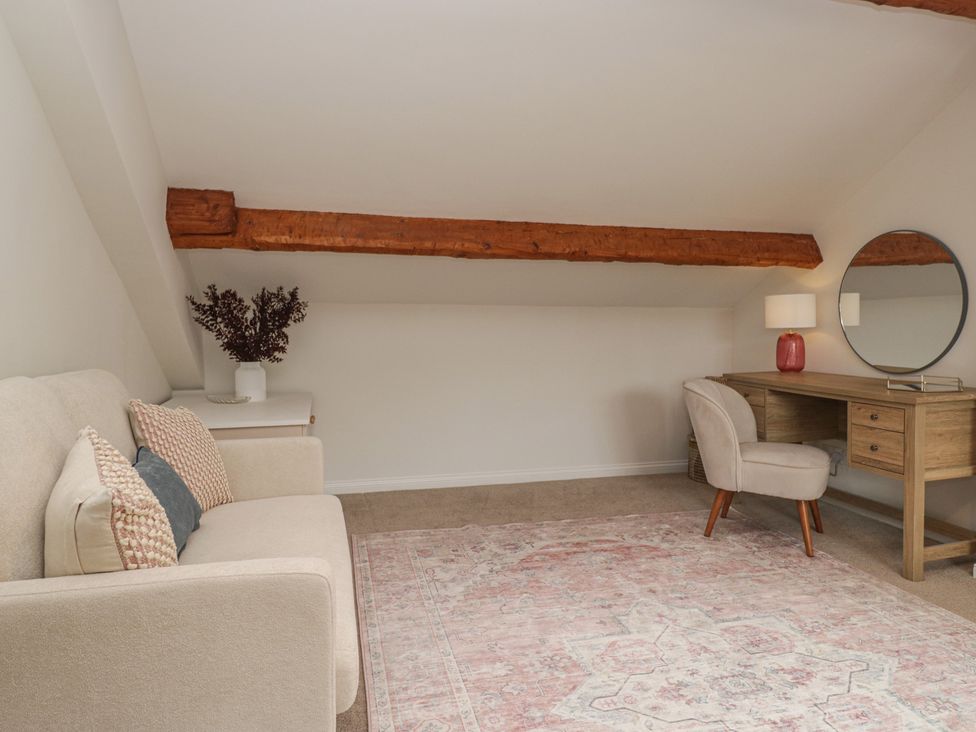 A snug with a sofa, desk, chair, and mirror at Cumbria house
