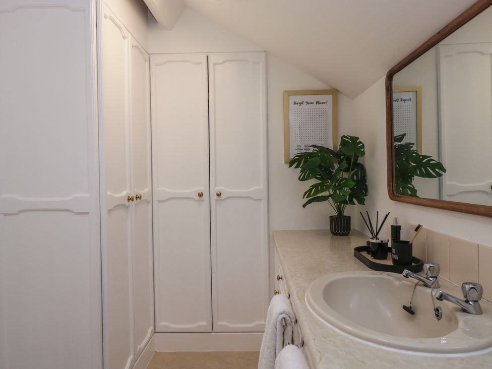 A bathroom with a sink and wardrobe at Cumbria house