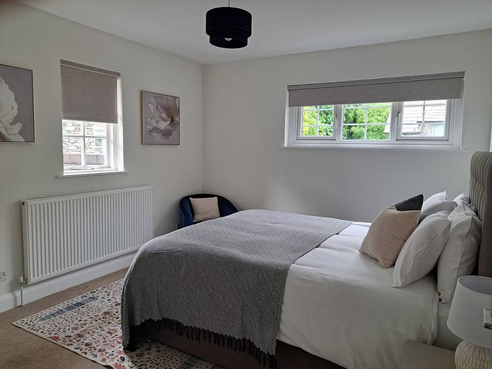 A bedroom with a bed, bedside table, and window at Cumbria house Grasmere