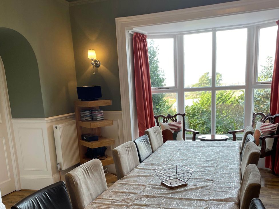 A dining room with a large table and chairs at Noddfa Country House, Harlech