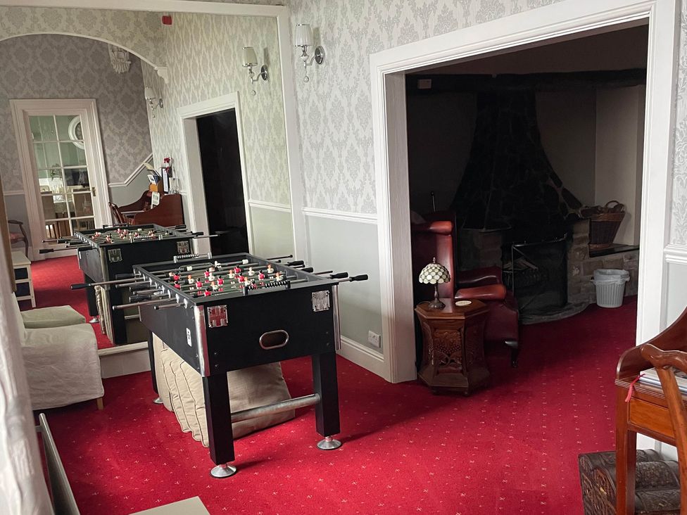 A game room with a foosball table and seating at Noddfa Country House Harlech