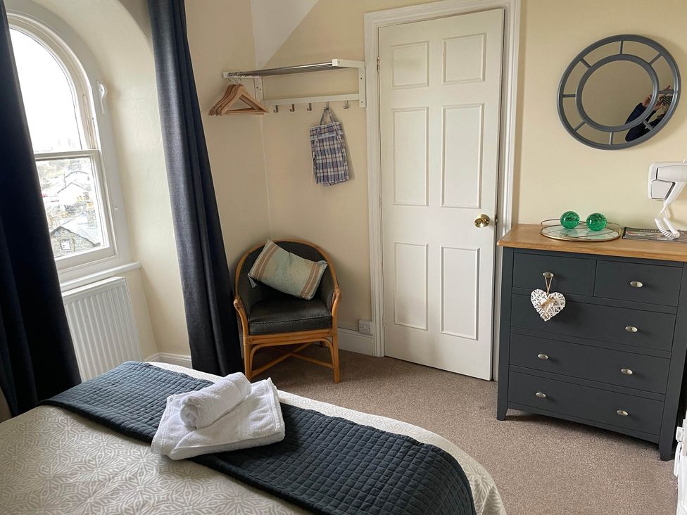 A bedroom with a bed and dresser at Noddfa Country House in Harlech
