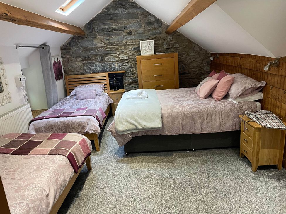 A bedroom with two beds and furniture at Noddfa Country House Harlech
