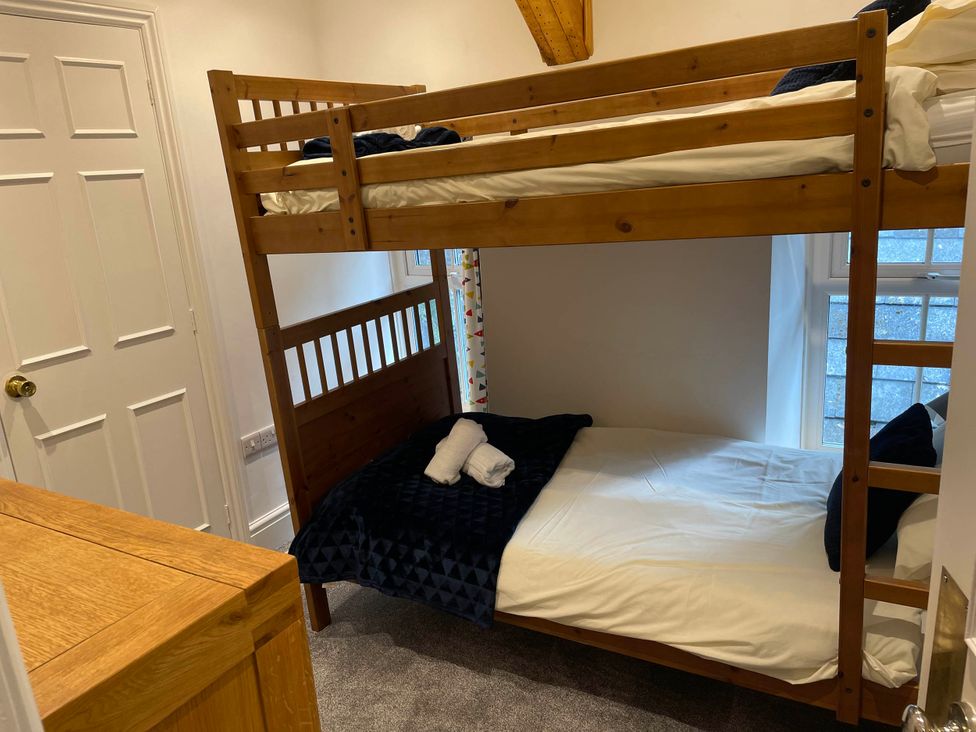 A bunk bed and a single bed in a bedroom at Noddfa Country House in Harlech