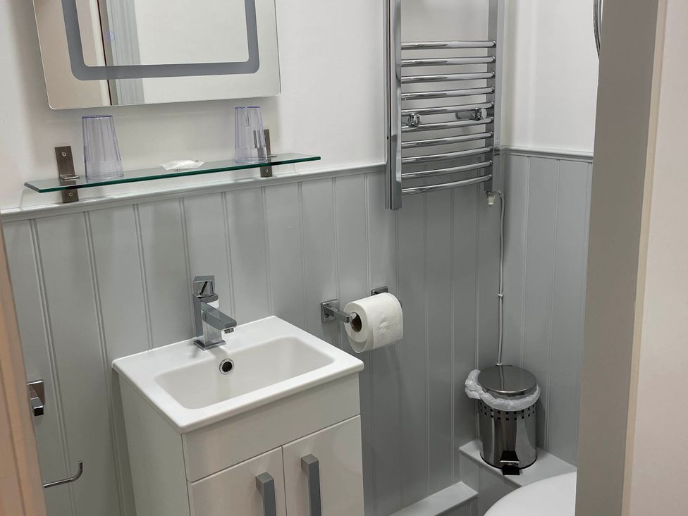 A bathroom with a sink and toilet at Noddfa Country House in Harlech