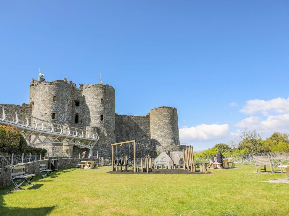 A playground with swings near a castle at Noddfa Country House in Harlech