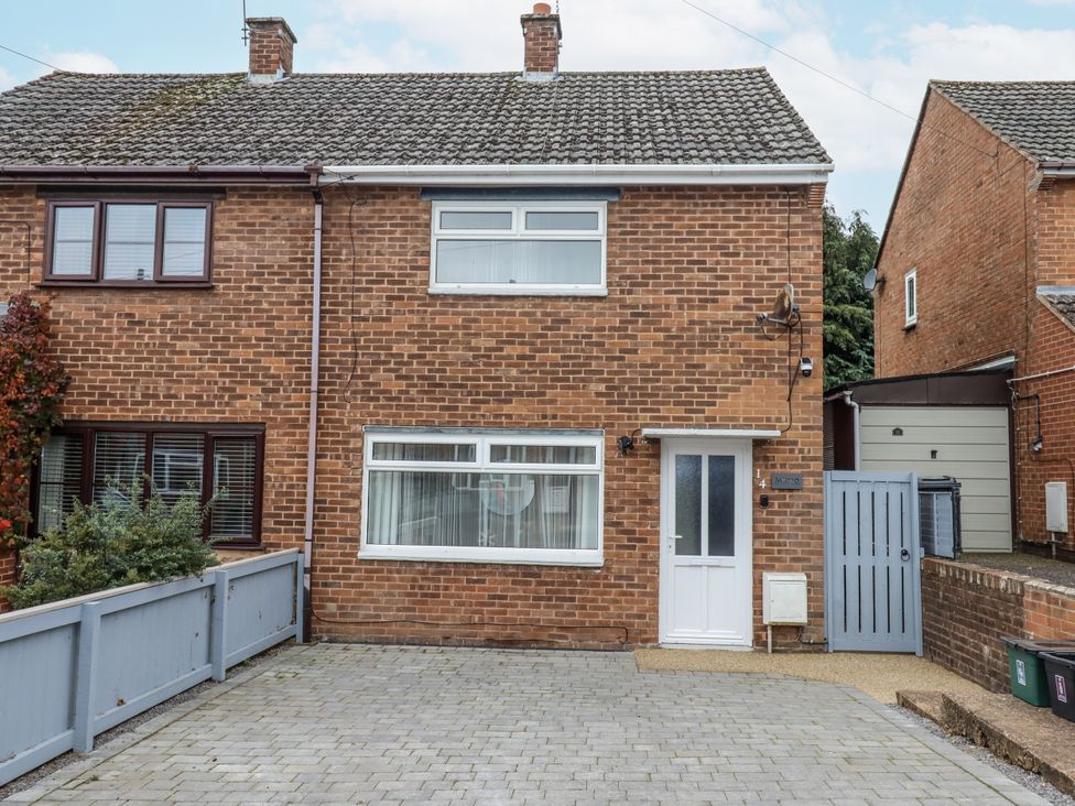 A brick house with windows and a driveway at Milana in Tiverton
