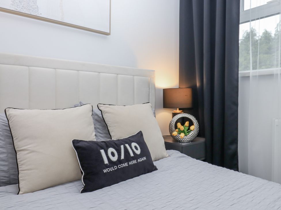 A bedroom with a bed and nightstand at Milana in Tiverton