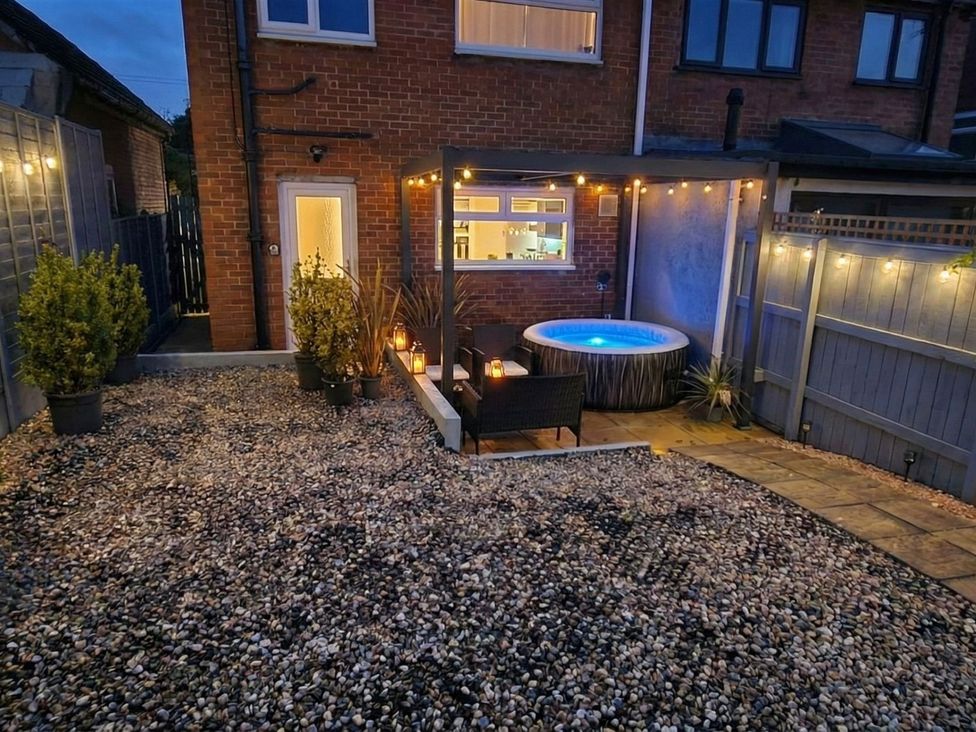 A garden with a hot tub and outdoor furniture at Milana in Tiverton