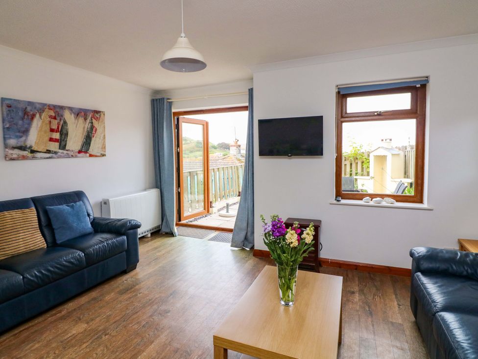 A living room with a sofa and television at Surf View in Hope Cove