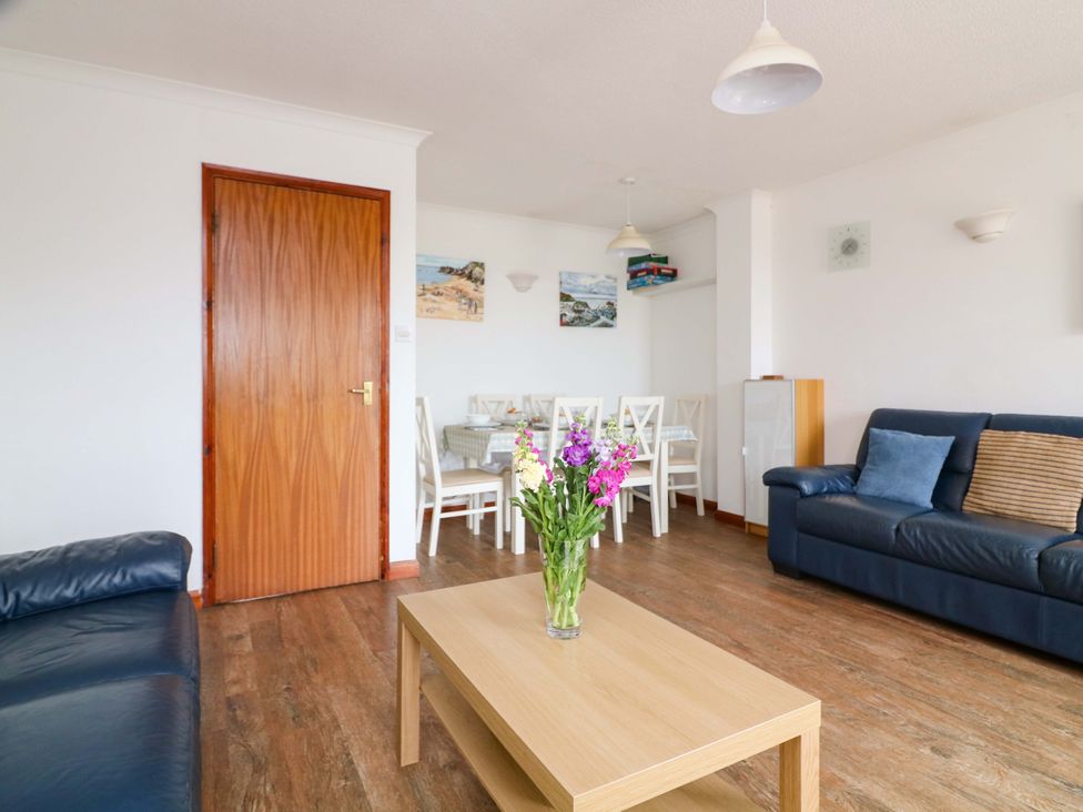 A living room with a table and chairs at Surf View in Hope Cove