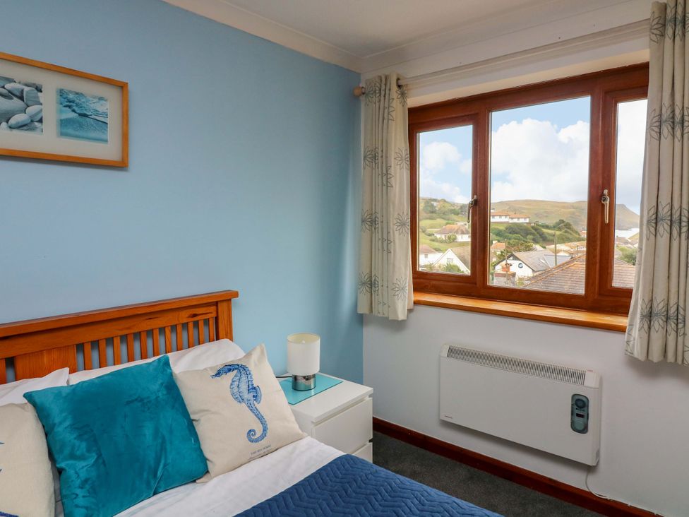A bedroom with a bed and window at Surf View in Hope Cove