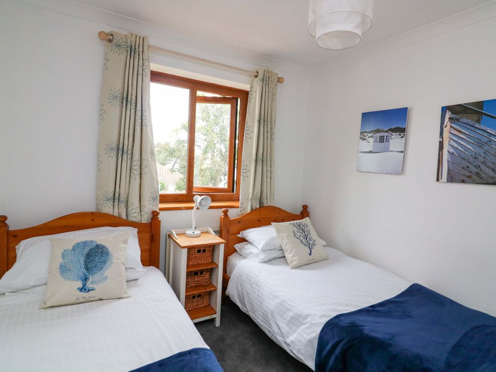 A bedroom with two beds and a window at Surf View in Hope Cove