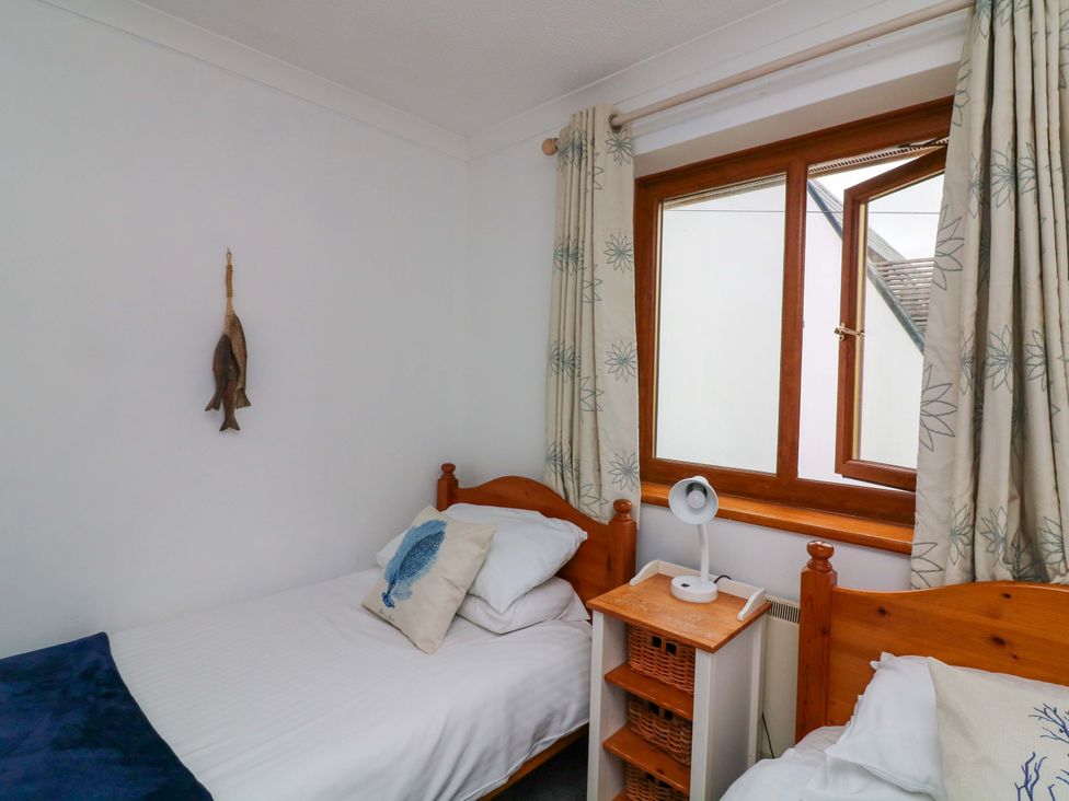 A bedroom with two beds and a window at Surf View in Hope Cove