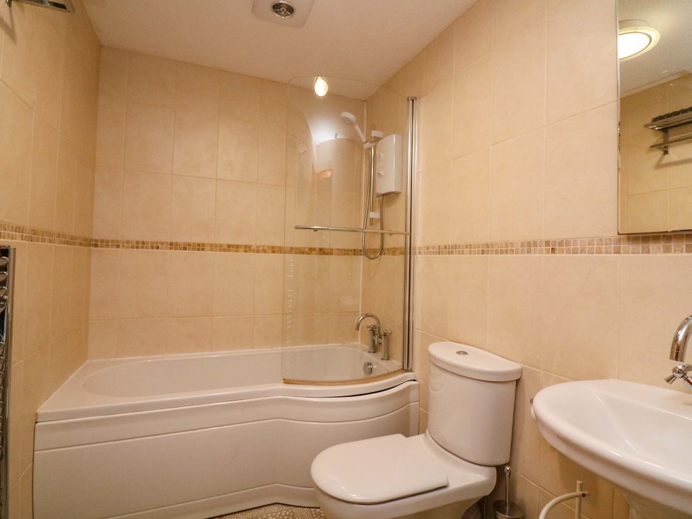 A bathroom with a bathtub, toilet, and sink at Surf View in Hope Cove