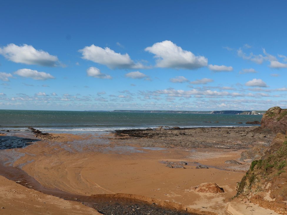 A beach scene with sand and sea at Surf View in Hope Cove