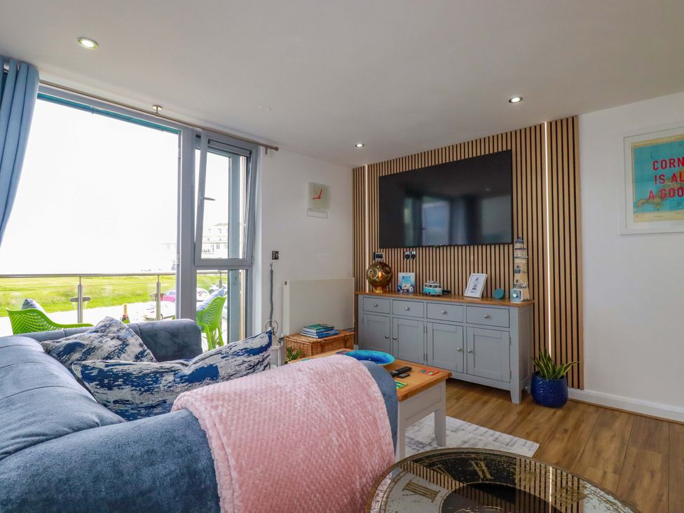 A living room with a sofa and a television at Penthouse @46Zinc - Headland View, Newquay