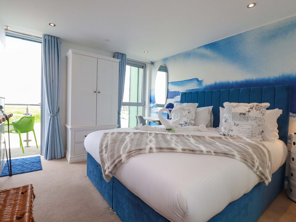 A bedroom with a bed and wardrobe at Penthouse @46Zinc - Headland View, Newquay