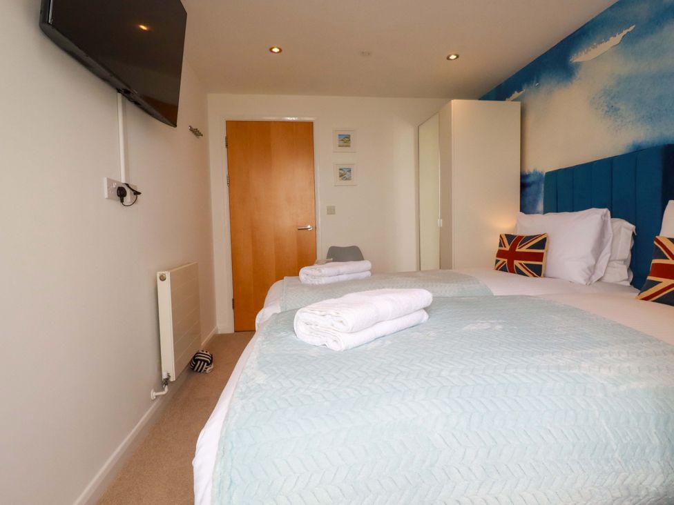 A bedroom with a bed and television at Penthouse @46Zinc - Headland View, Newquay