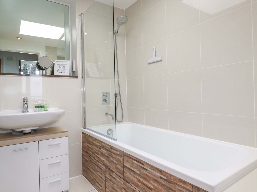 A bathroom with a sink and bathtub at Penthouse @46Zinc - Headland View in Newquay
