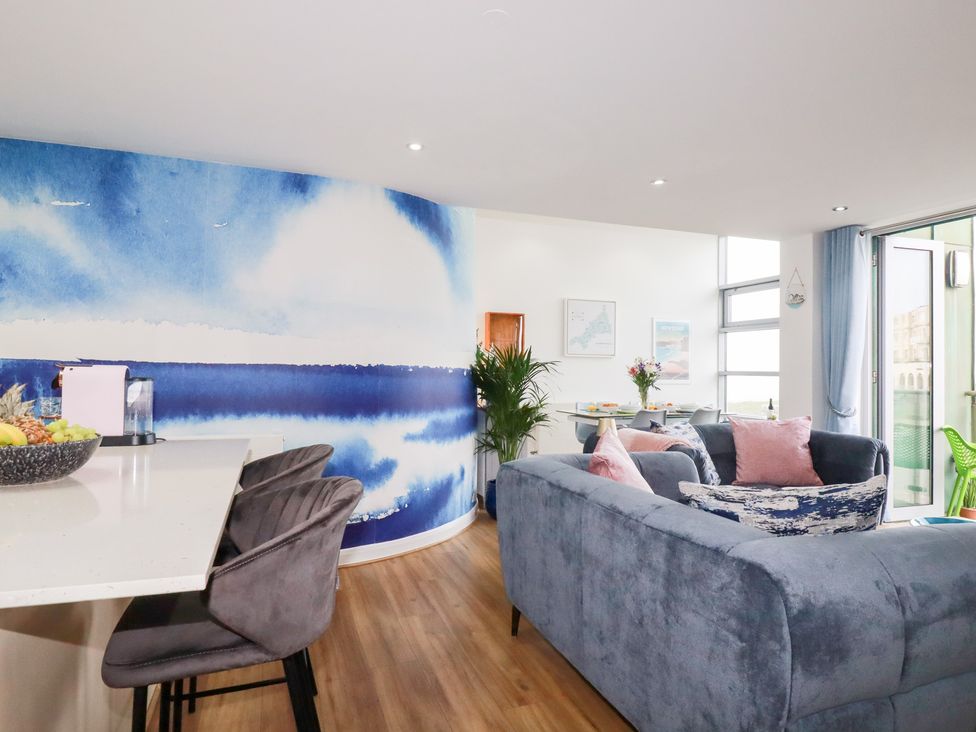 A living room with a blue wall and fruit bowl at Penthouse @46Zinc - Headland View Newquay