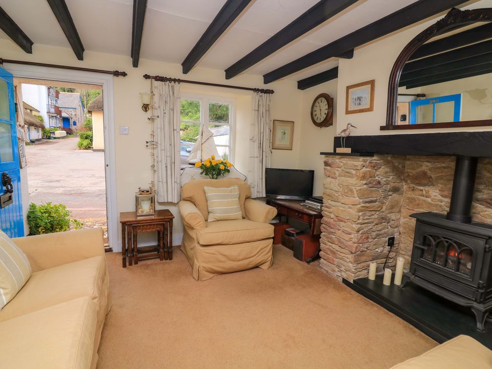 A living room with a fireplace and television at 1 The Square in Hope Cove