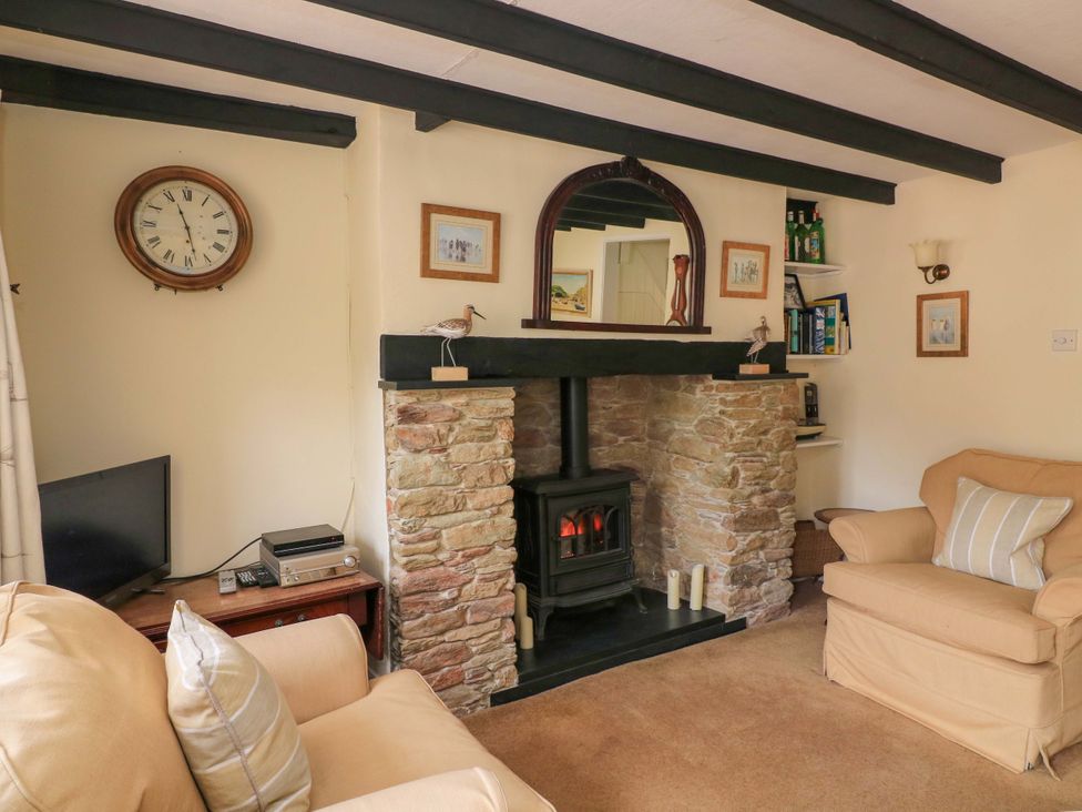 A living room with a fireplace and sofa at 1 The Square in Hope Cove