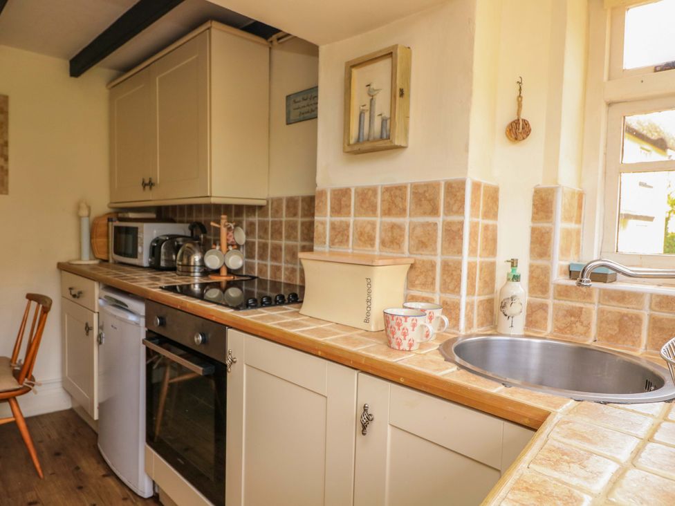 A kitchen with countertop, sink, and appliances at 1 The Square Hope Cove