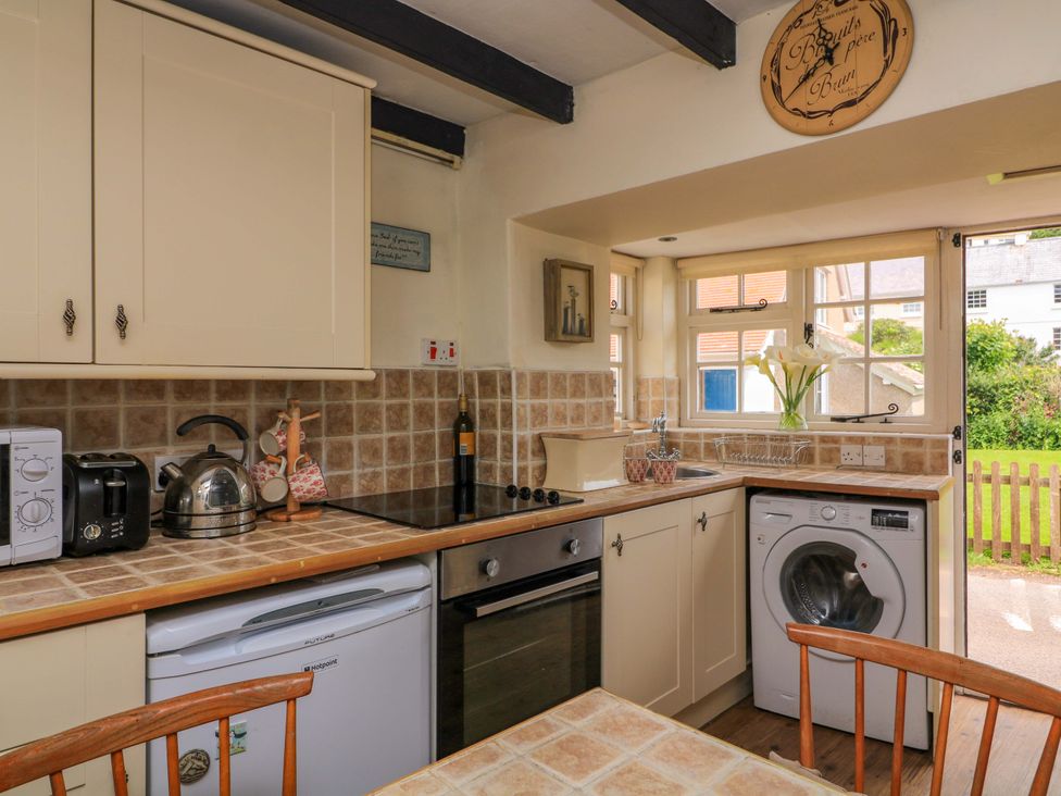 A kitchen with appliances including a kettle and washing machine at 1 The Square, Hope Cove
