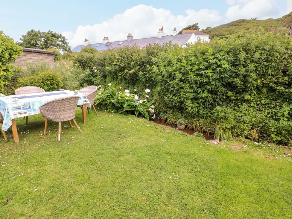A garden with a table and chairs at 1 The Square Hope Cove