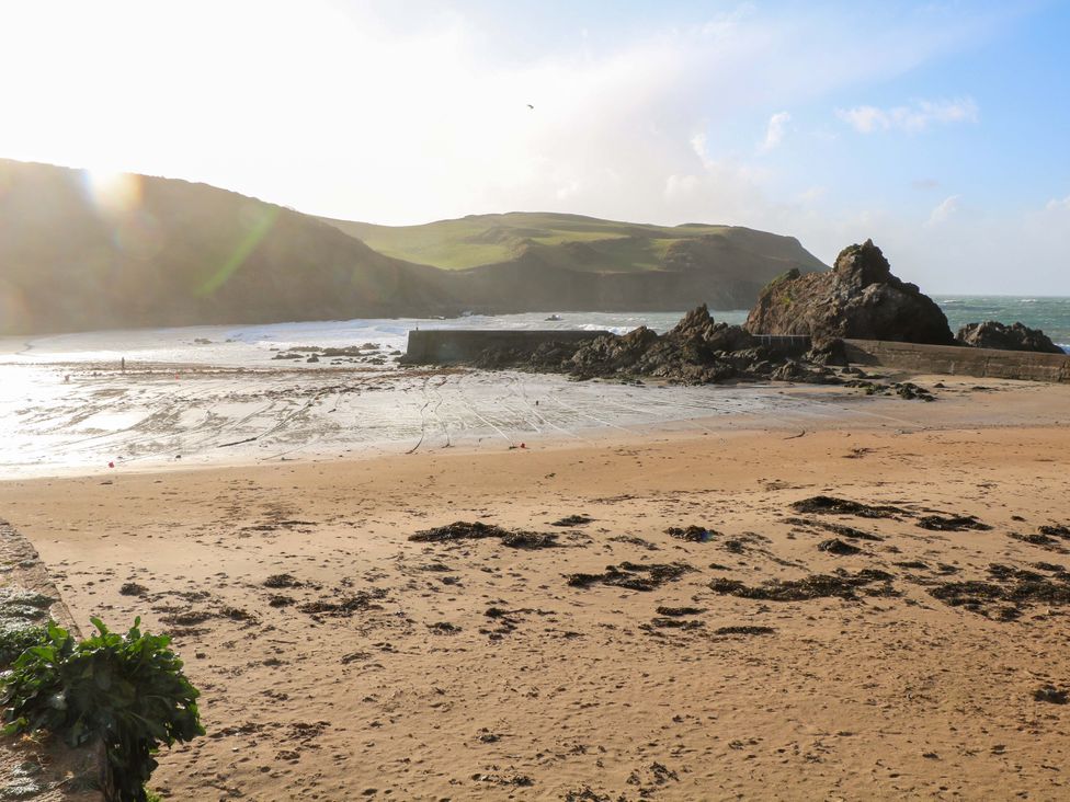 A beach with sand and rocks at 1 The Square Hope Cove