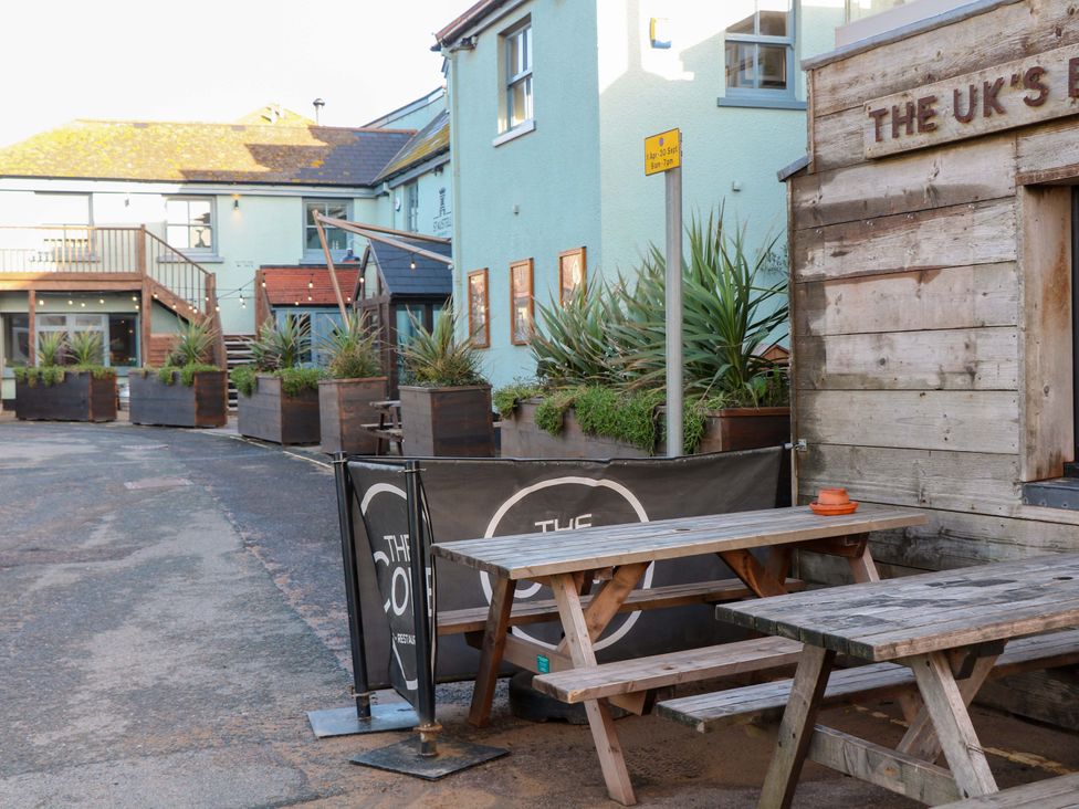 A seating area with tables and planters at 1 The Square Hope Cove