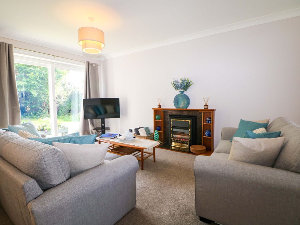 A living room with sofas and a TV at 6 Ashton Gardens in Rustington