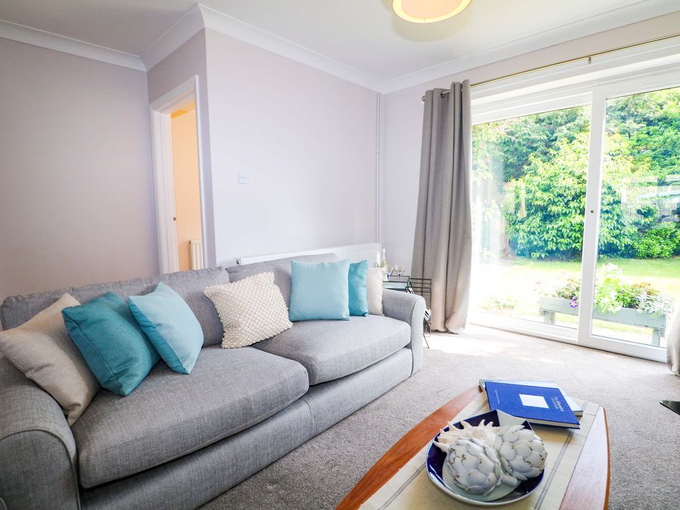 A living room with a sofa and table at 6 Ashton Gardens Rustington