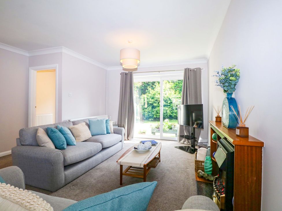A living room with a sofa and television at 6 Ashton Gardens in Rustington
