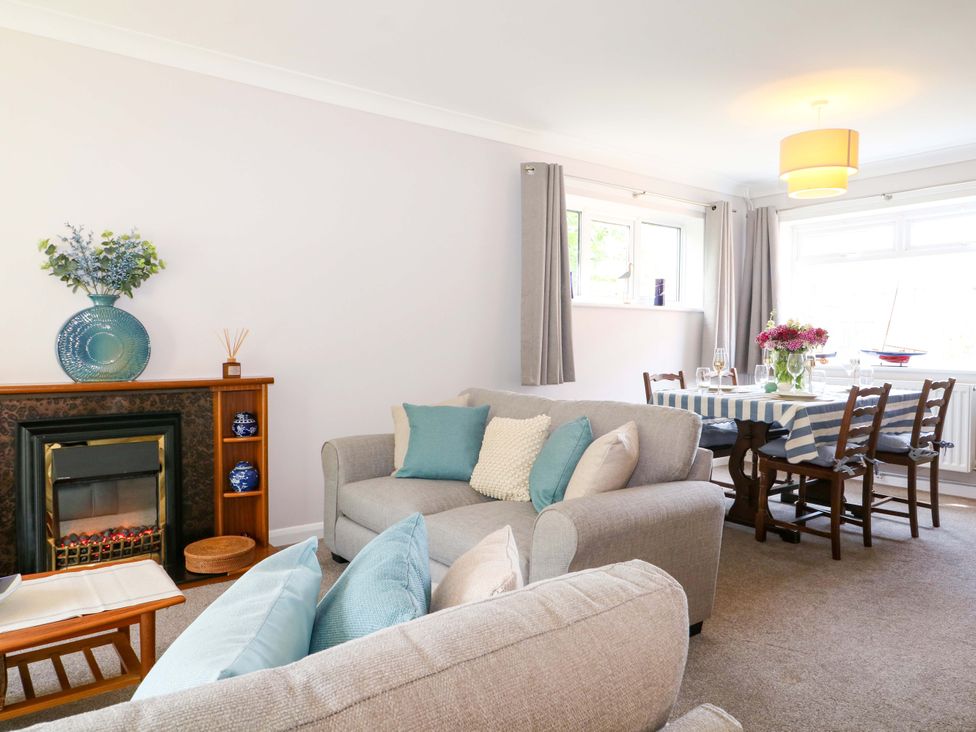 A living room with a sofa and dining area at 6 Ashton Gardens Rustington