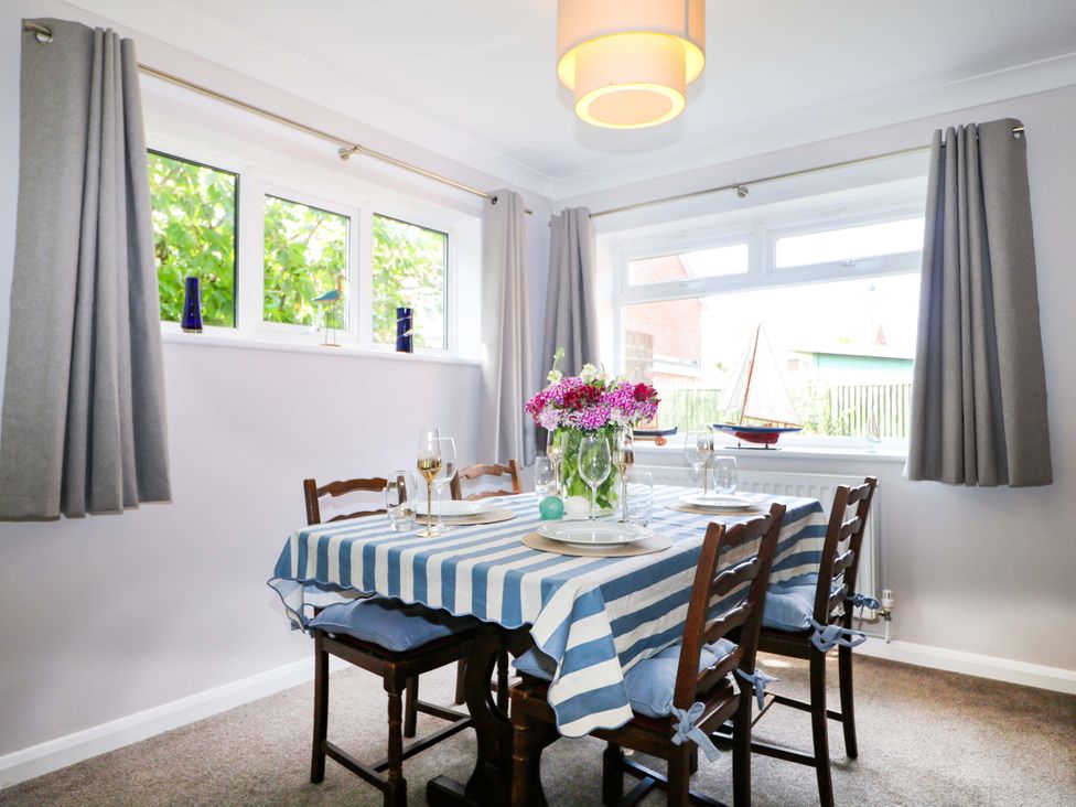 A dining room with a table and chairs at 6 Ashton Gardens in Rustington