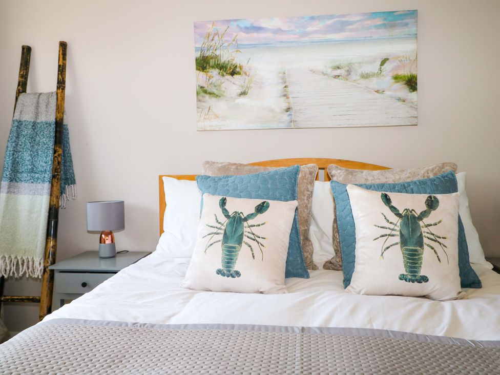 A bedroom with a bed and pillows at 6 Ashton Gardens, Rustington