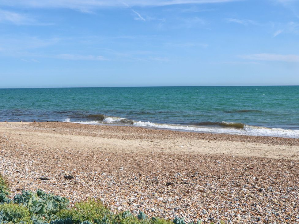 A beach with sand and waves at 6 Ashton Gardens Rustington