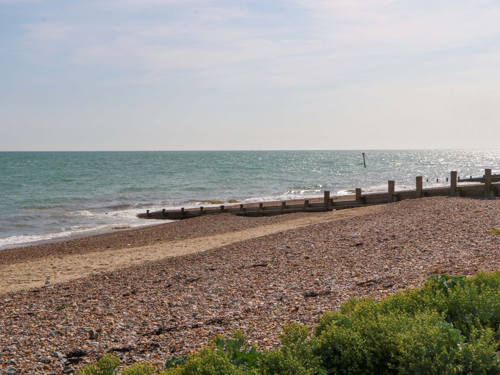 A beach with pebbles and wooden posts at 6 Ashton Gardens in Rustington