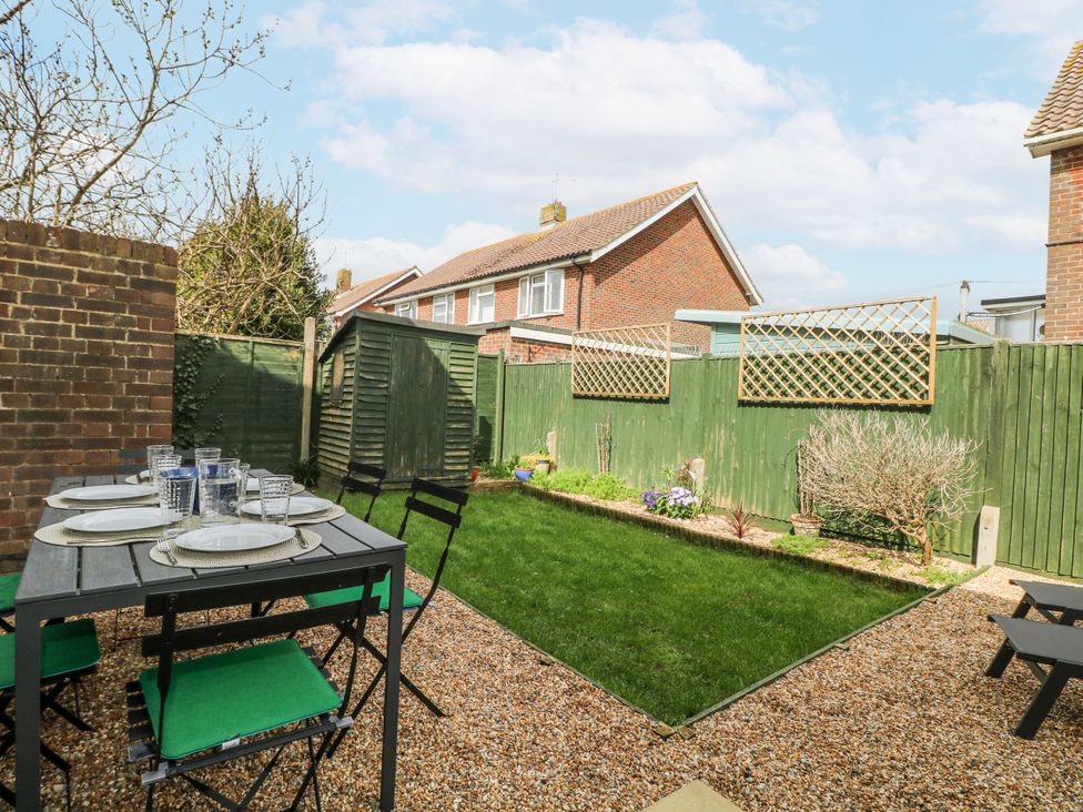A garden with a dining table and chairs at Pebble Place in Rustington