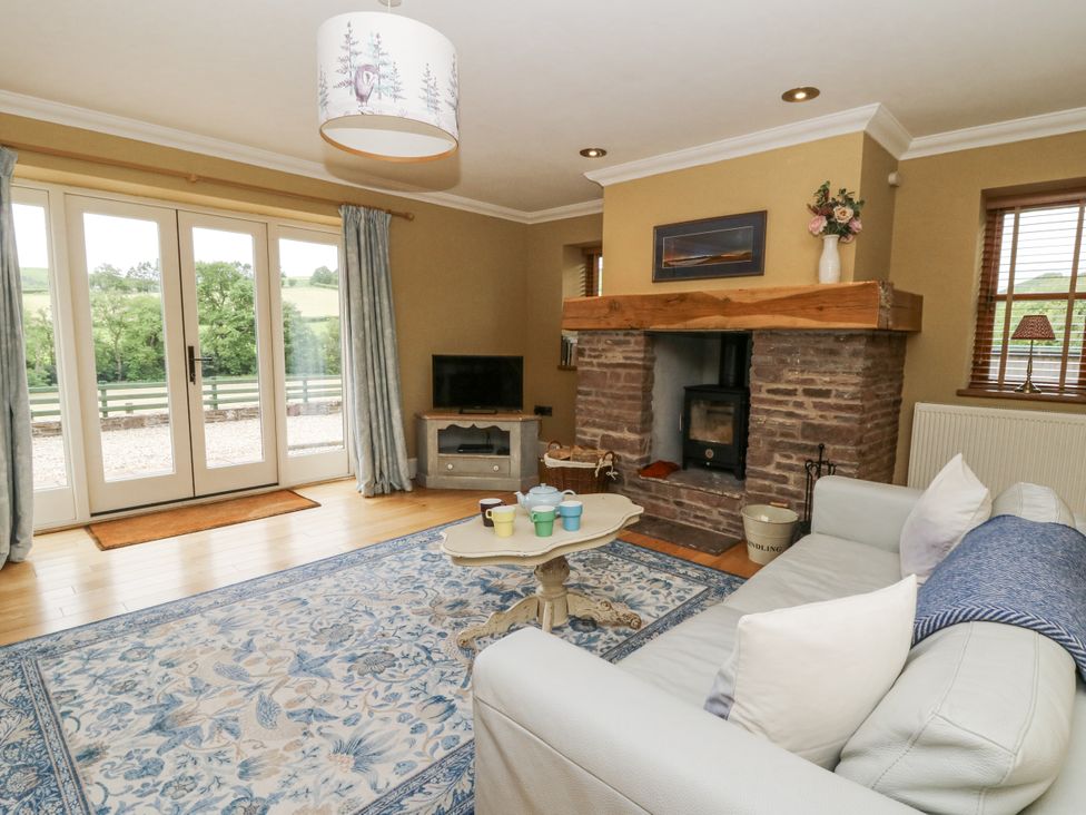 A living room with a fireplace and sofa at Waun Yscir in Merthyr Cynog near Brecon