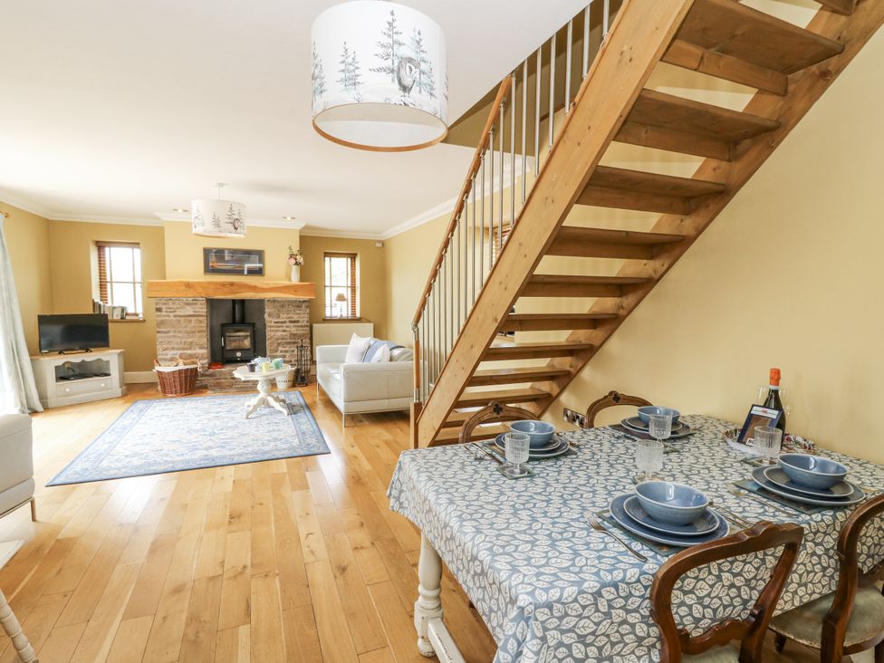 A living room with dining table and staircase at Waun Yscir in Merthyr Cynog near Brecon