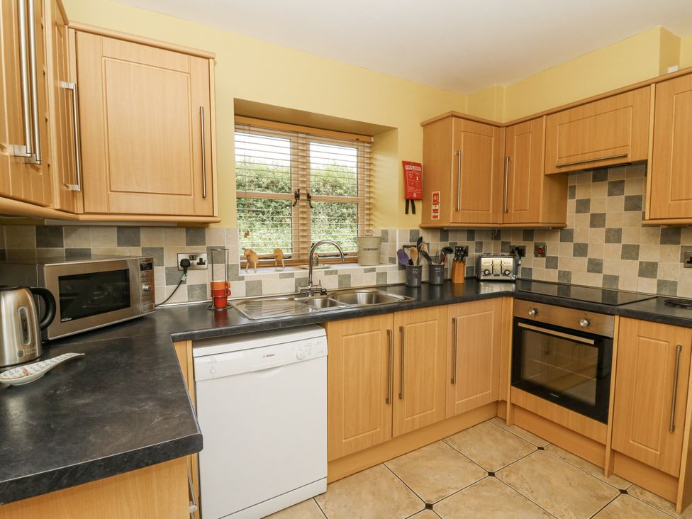 A kitchen with cabinets, sink, and appliances at Waun Yscir Merthyr Cynog near Brecon