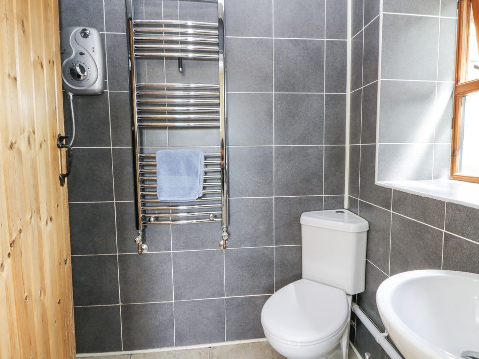 A bathroom with a toilet, sink, and towel rail at Waun Yscir Merthyr Cynog near Brecon