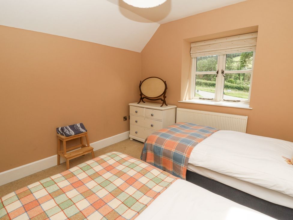 A bedroom with two beds, a dresser and a mirror at Waun Yscir near Brecon
