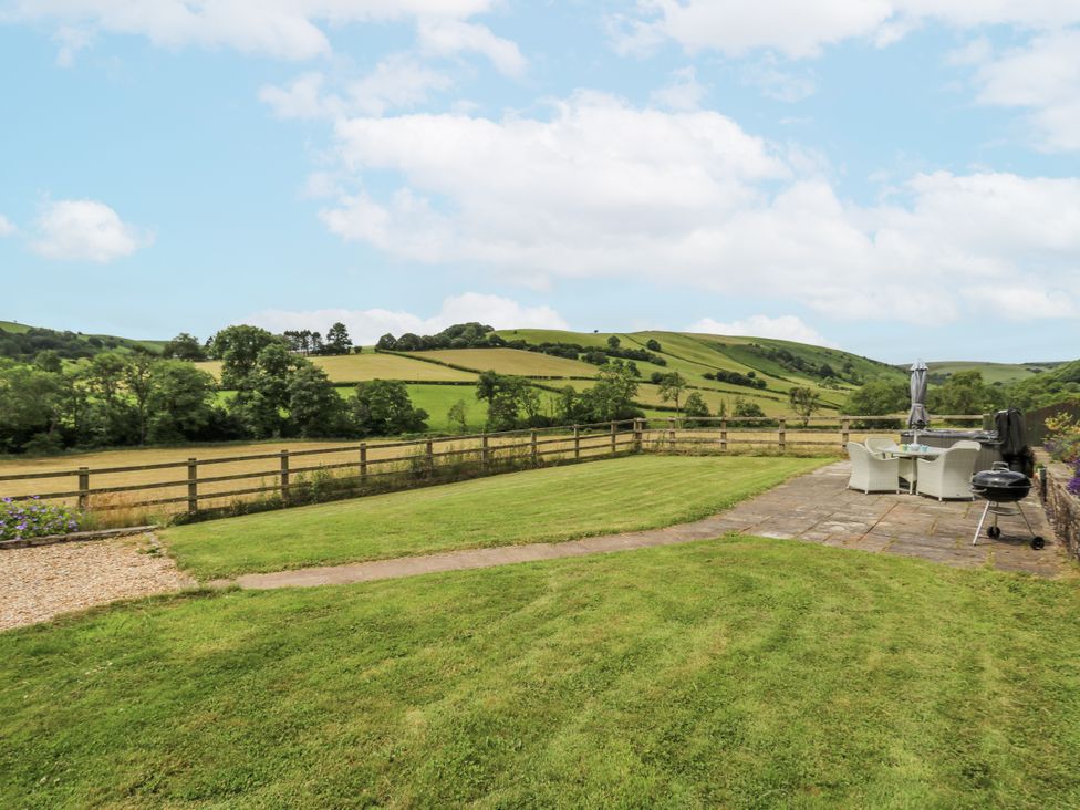 A garden with patio furniture and a barbecue at Waun Yscir near Merthyr Cynog