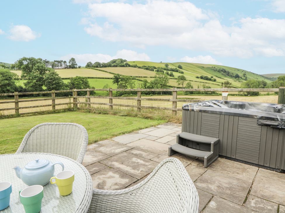 An outdoor area with a hot tub and seating at Waun Yscir Merthyr Cynog near Brecon